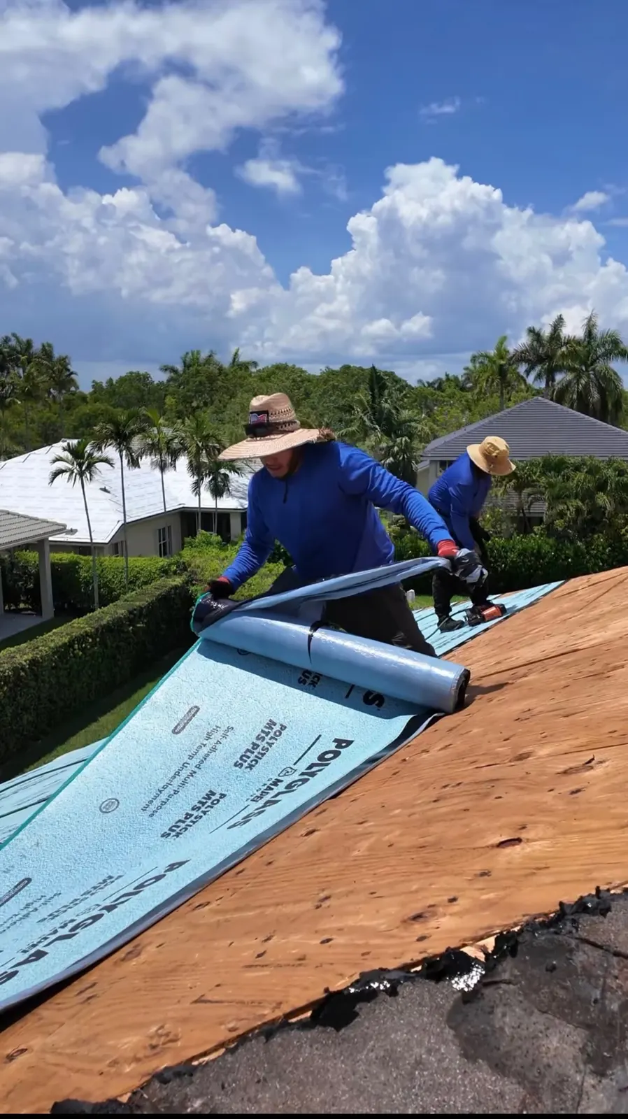 Roofer rolling out underlayment on a new roof deck.